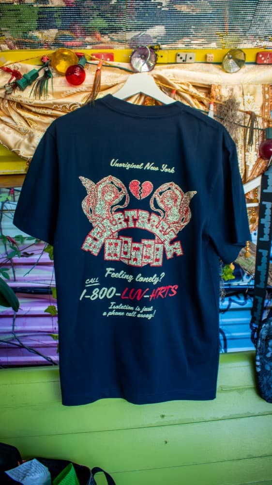 A branded tee hanging at an event merch display