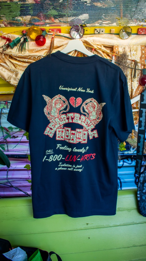 A branded tee hanging at an event merch display
